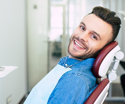Man smiling in dental chair after dentistry treatment