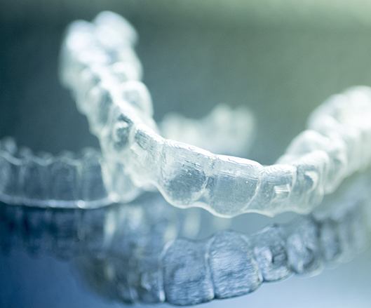  close-up of two Invisalign aligners 
