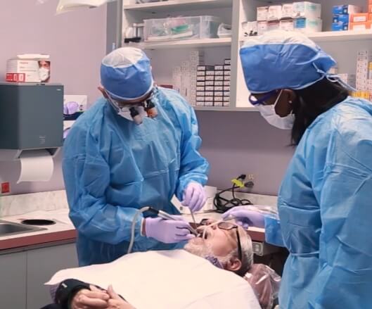 Doctor Modarres and team member treating dental patient