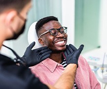 Dentist looking at patient's smile in treatment room