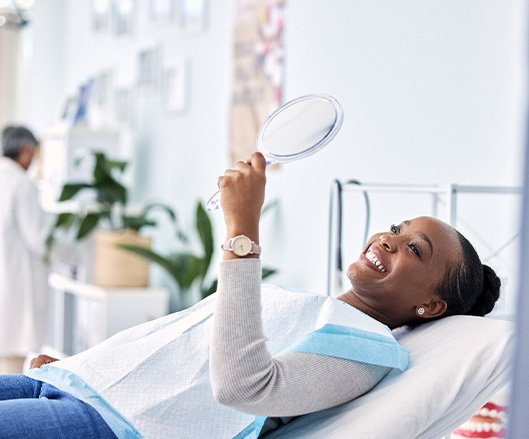 Woman smiling while looking at reflection in mirror