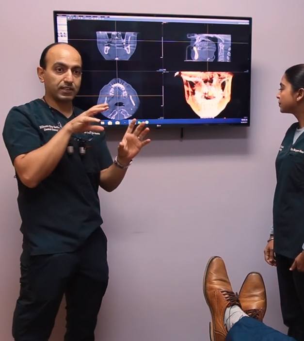 Dentists showing digital x-rays and treatment plan to dental patient