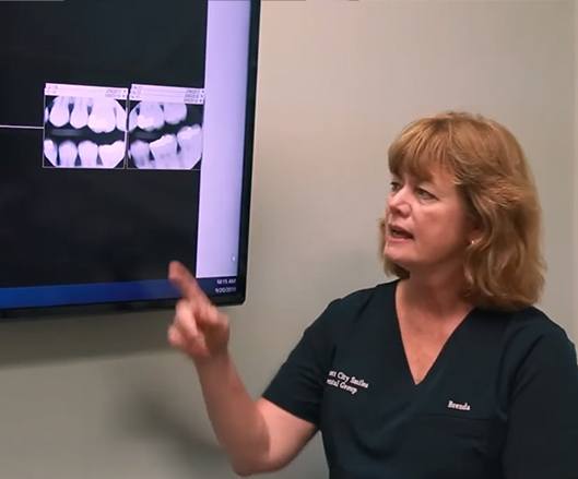 Dental team member pointing to digital x-rays