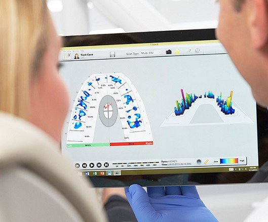 Dentist and dental patient looking at cavity detection system readings