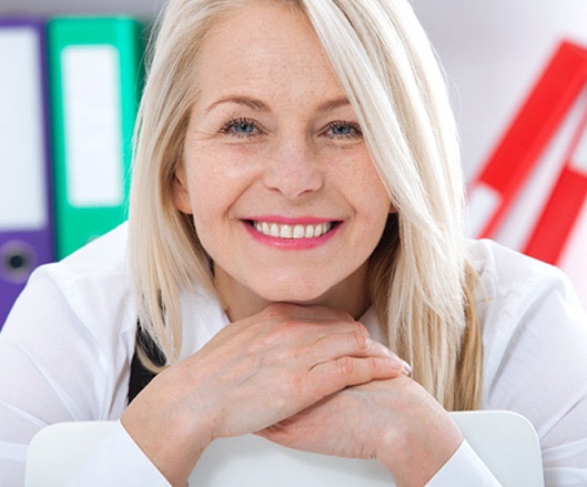 Woman with implant-retained denture smiling.