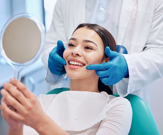 patient smiling and looking in the mirror after treatment