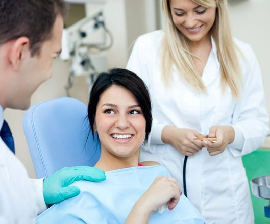 Smiling dental patient speaking with dental team