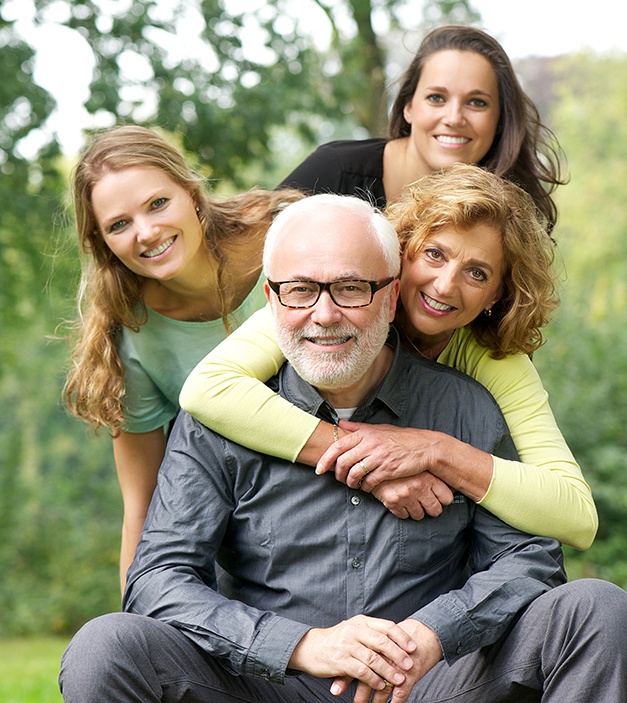 Smiling family after visiting the dentist for treatment covered by dental insurance