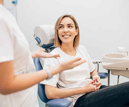 Woman discussing dental insurance with dental team member