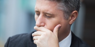 Man in need of emergency dentistry covering mouth