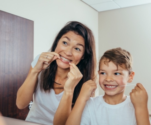 Mother and son flossing teeth together