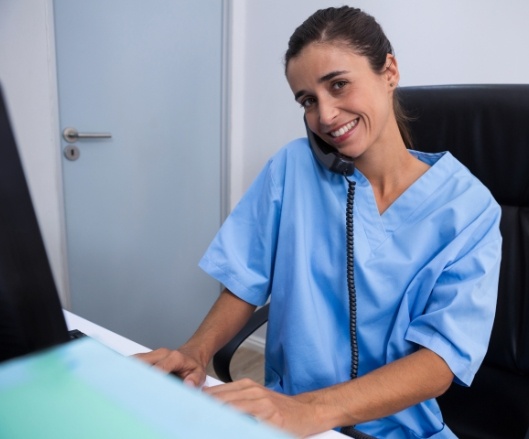 Smiling dental team member answering phone