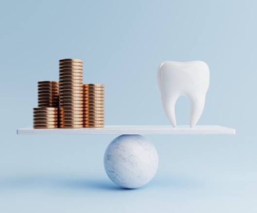 Tooth balanced against stacks of coins on scale