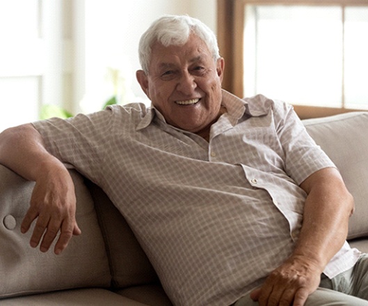 a person smiling and sitting on a couch