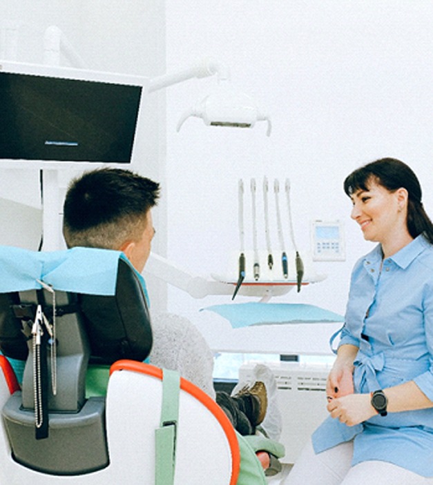 Man in dental chair for full mouth reconstruction consultation.