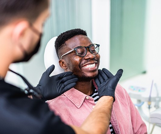 Dentist looking at patient's smile in treatment room