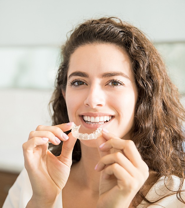 Woman placing Invisalign tray