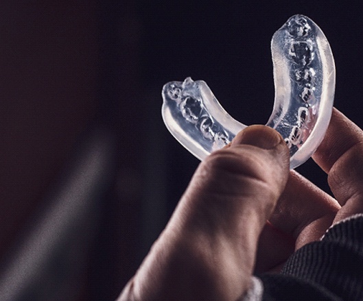Man holding mouthguard in Ellicott City