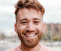 a smiling person standing outside