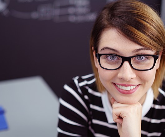 Woman smiling after porcelain veneer cosmetic dental restoration