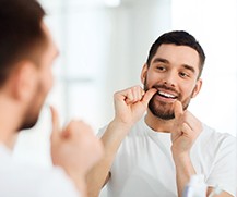 man flossing in bathroom