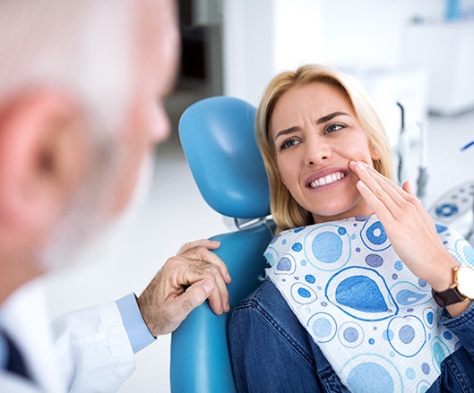 Woman talking to dentist about tooth pain