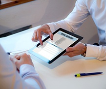 A dental insurance form being discussed by a patient and an insurance agent