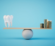 A balance beam illustrating a model tooth and gold coins