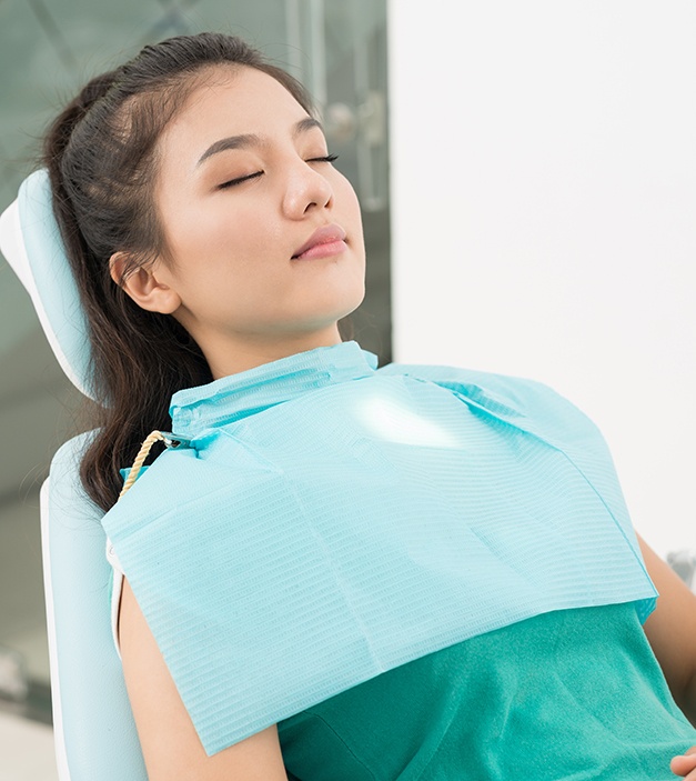 Relaxed patient under dental sedation in dental chair