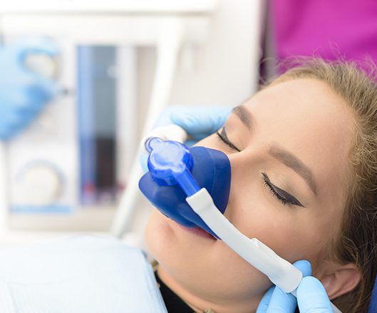 Woman with nitrous oxide sedation dentistry mask in place