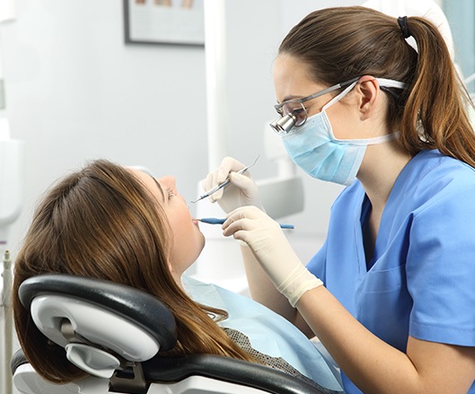 Woman receiving tooth extraction treatment