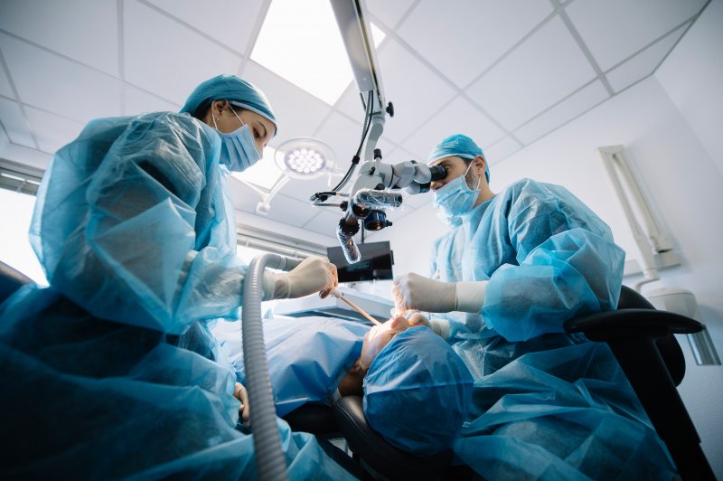 Oral surgeons performing a dental implant surgery